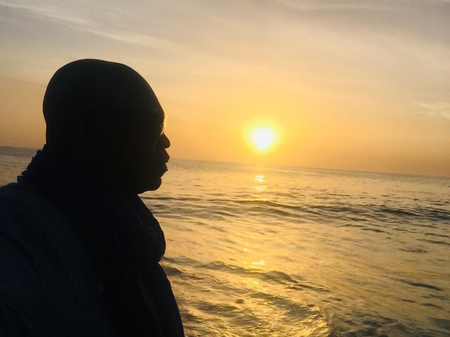 Alex Boicel face à l’océan au coucher du soleil